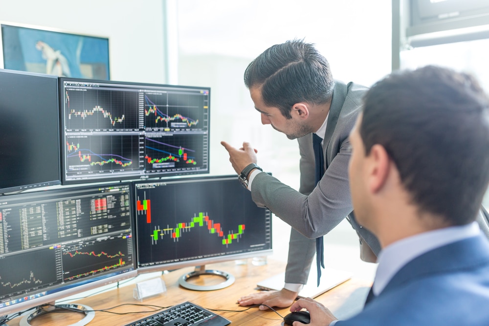 BusinessmenTradingStocksOnlineStockBrokersLookingAtGraphsIndexes