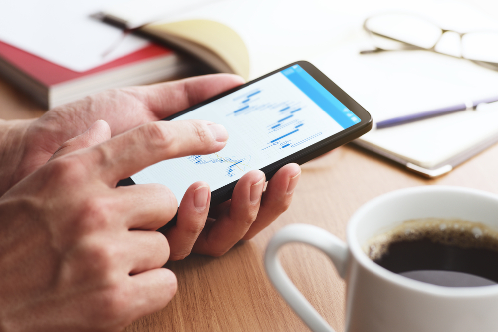StockMarketChartsOnSmartphoneScreenCloseupOfMaleHands
