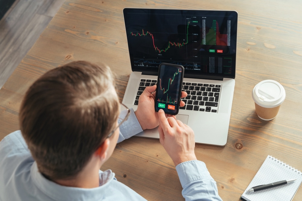 OverShoulderTopViewOfBusinessManTraderInvestorUsing